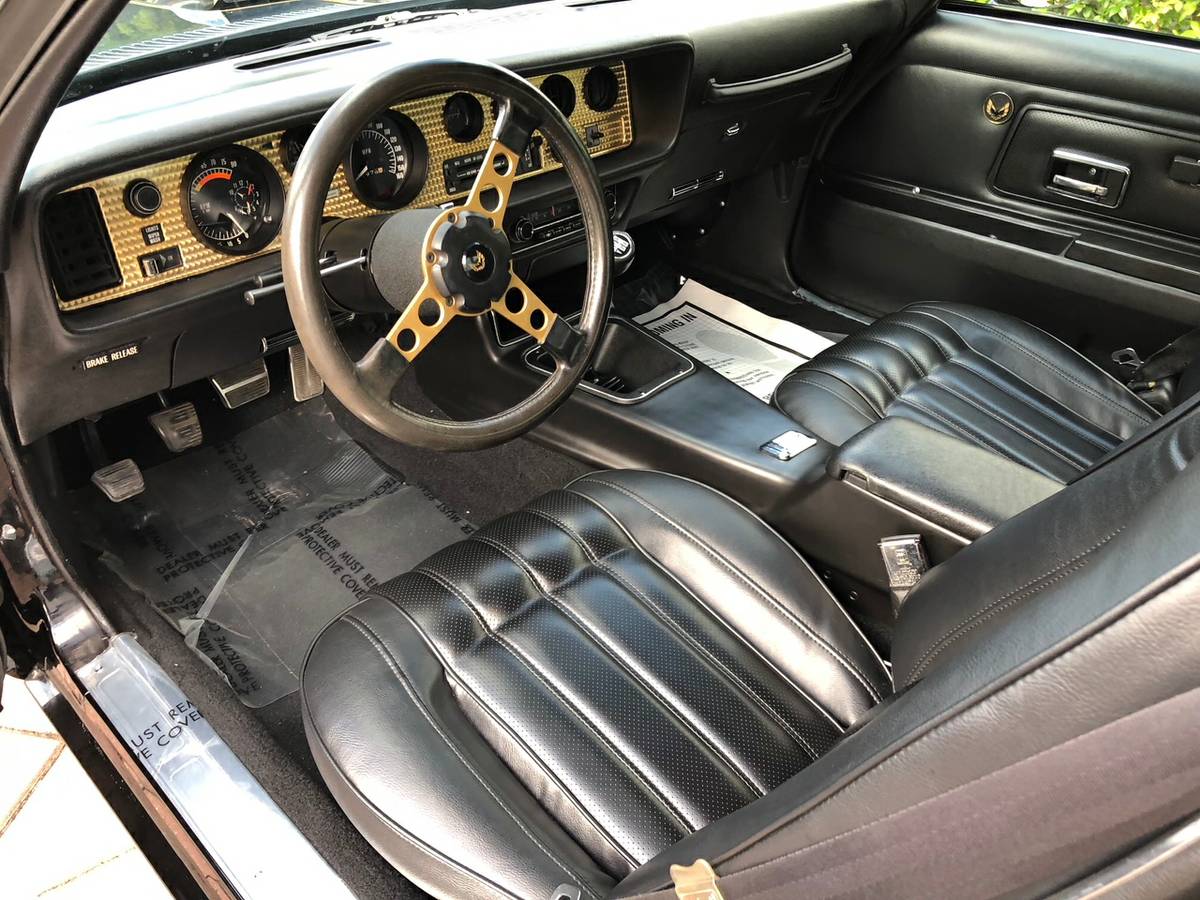Inside picture from driver side. Black leather seats and gold dashboard.